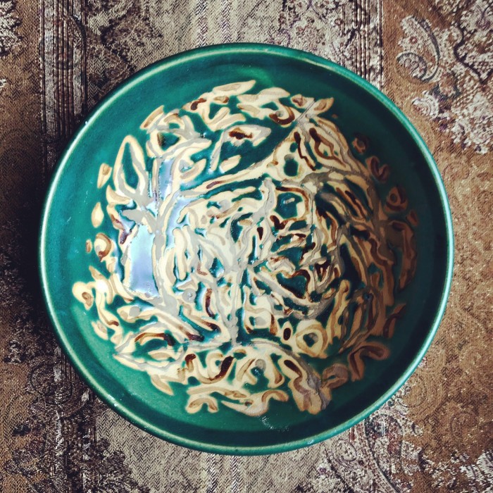 7/2019. Interior of Green Bowl with Slip Painting and Wax Resist